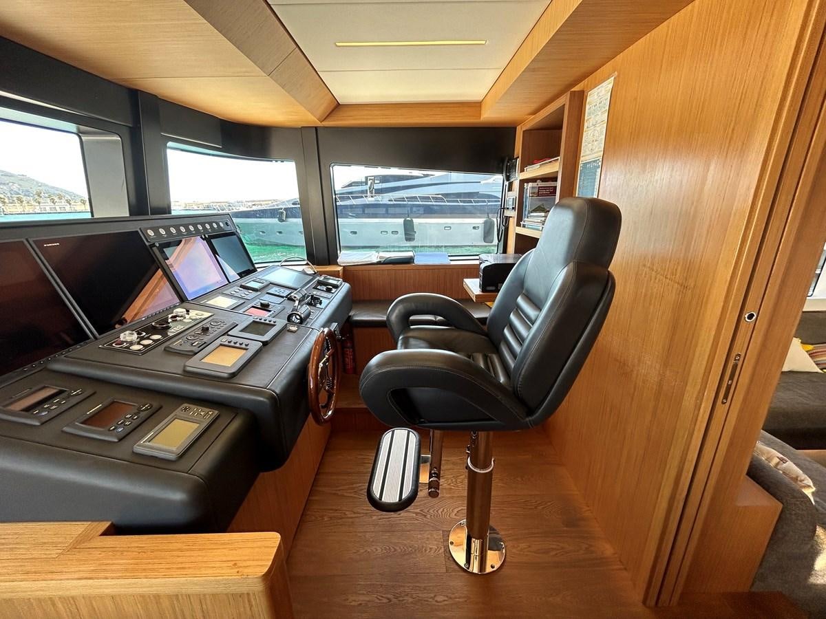 a black office chair in front of a computer desk aboard YES Yacht for Sale