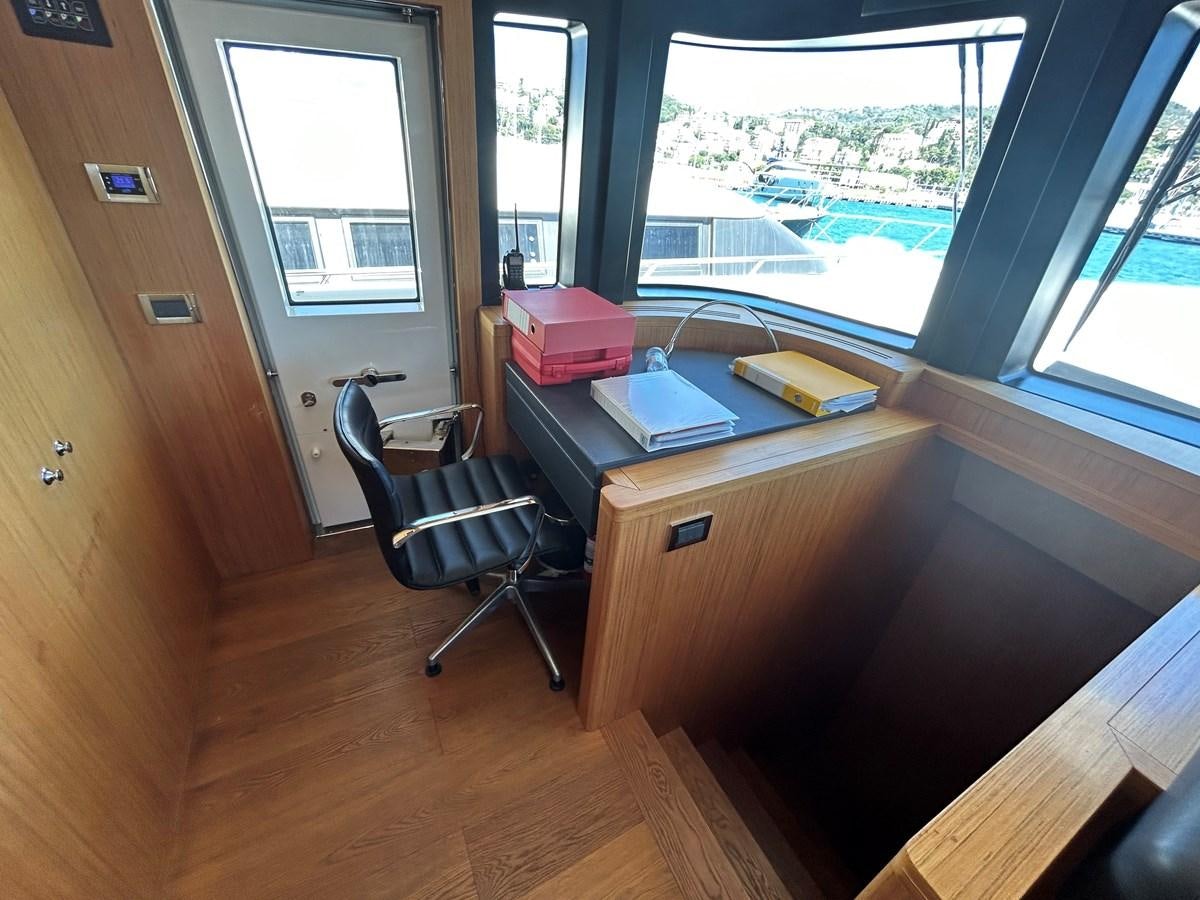 a room with a desk and a window aboard YES Yacht for Sale