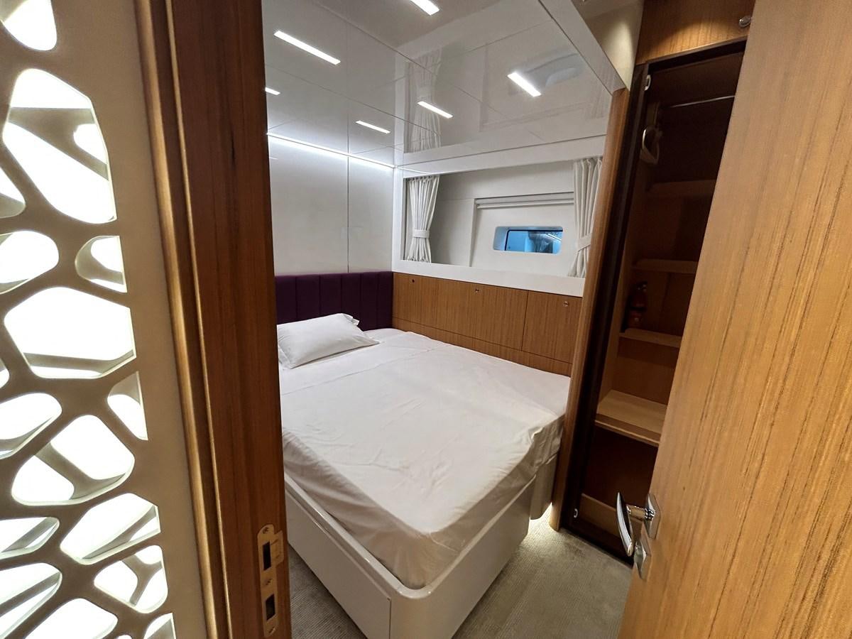 a room with a bed and a mirror aboard YES Yacht for Sale