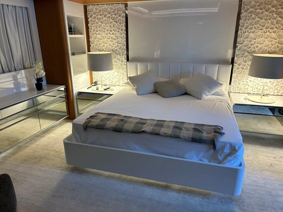 a bed with a blue comforter aboard YES Yacht for Sale
