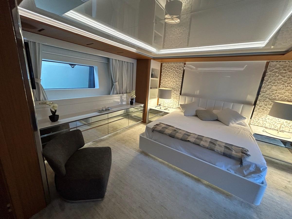 a bedroom with a bed and a chair aboard YES Yacht for Sale