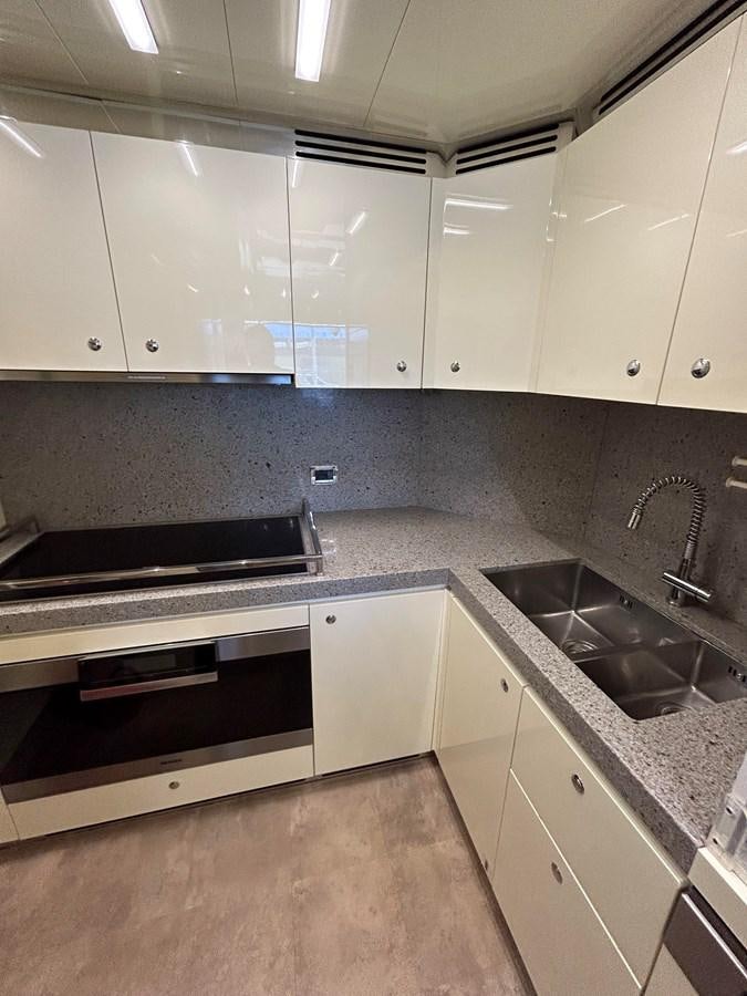 a kitchen with white cabinets aboard YES Yacht for Sale