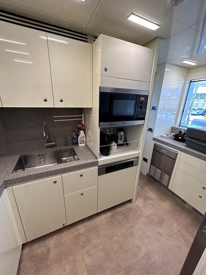 a kitchen with white cabinets aboard YES Yacht for Sale