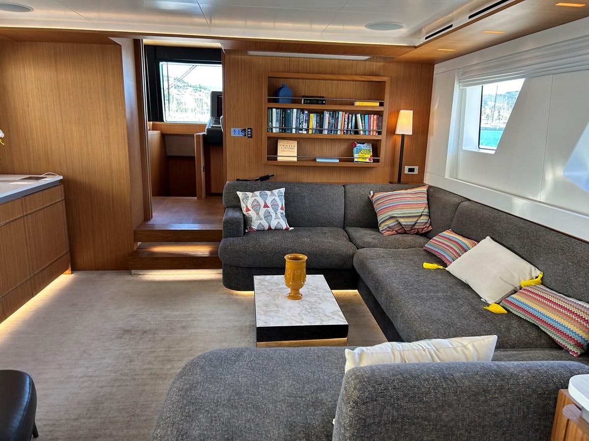 a living room with a couch and a coffee table aboard YES Yacht for Sale