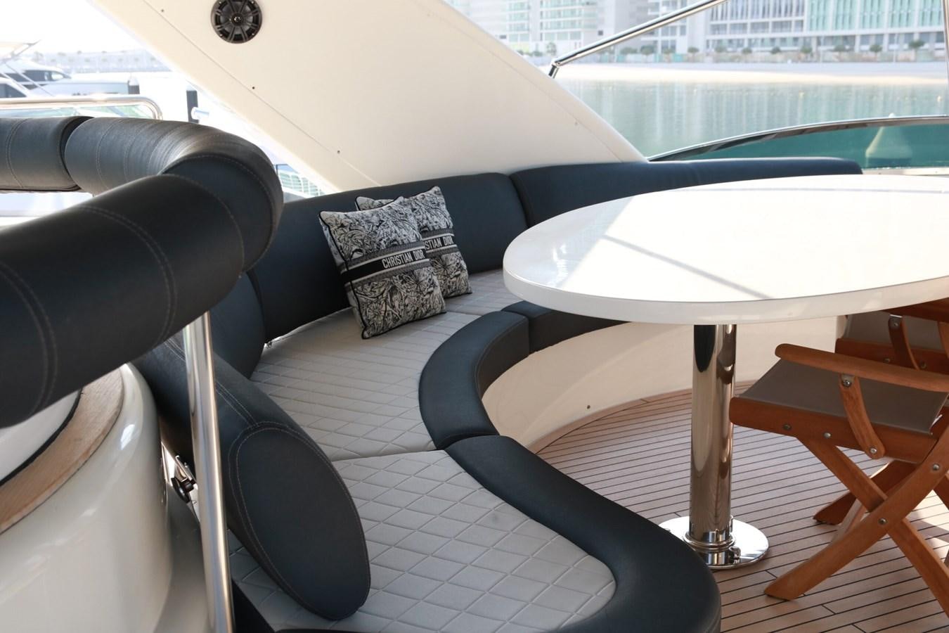 a black couch with a white table and chairs on it aboard SIMONA Yacht for Sale