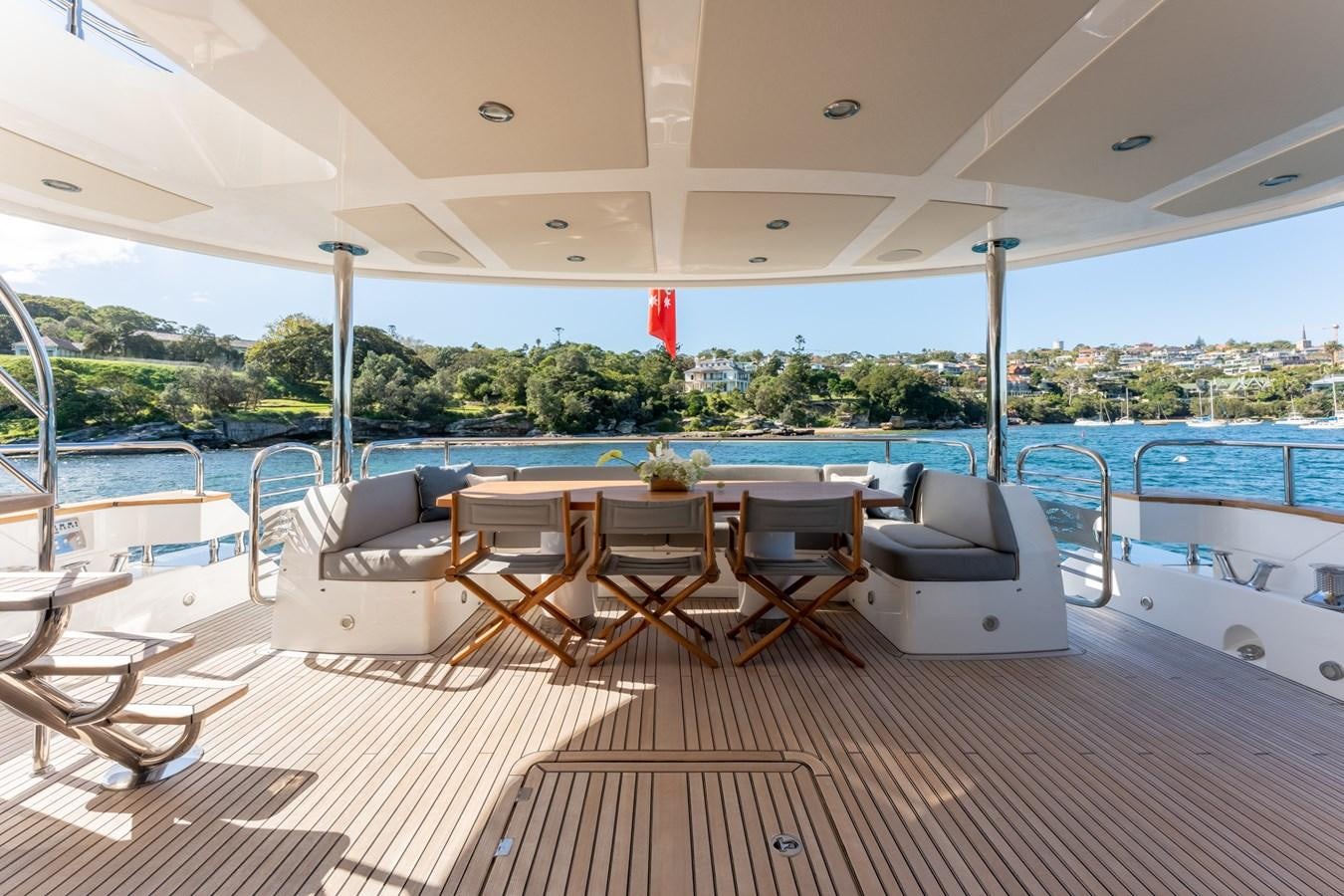 a large swimming pool with chairs and tables and a large building in the background aboard ULTRAVIOLET Yacht for Sale