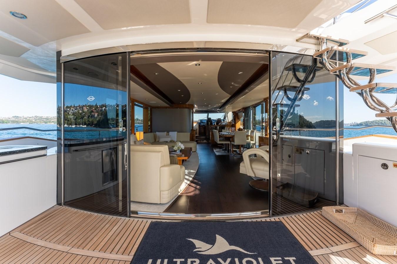 inside of a building with a glass door and a view of the water aboard ULTRAVIOLET Yacht for Sale