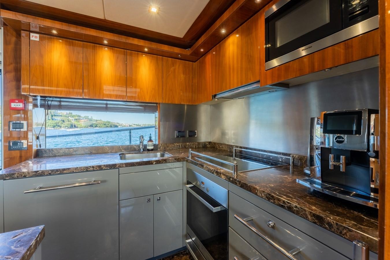 a kitchen with wooden cabinets aboard ULTRAVIOLET Yacht for Sale