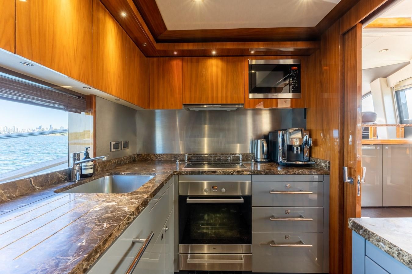 a kitchen with wooden cabinets aboard ULTRAVIOLET Yacht for Sale