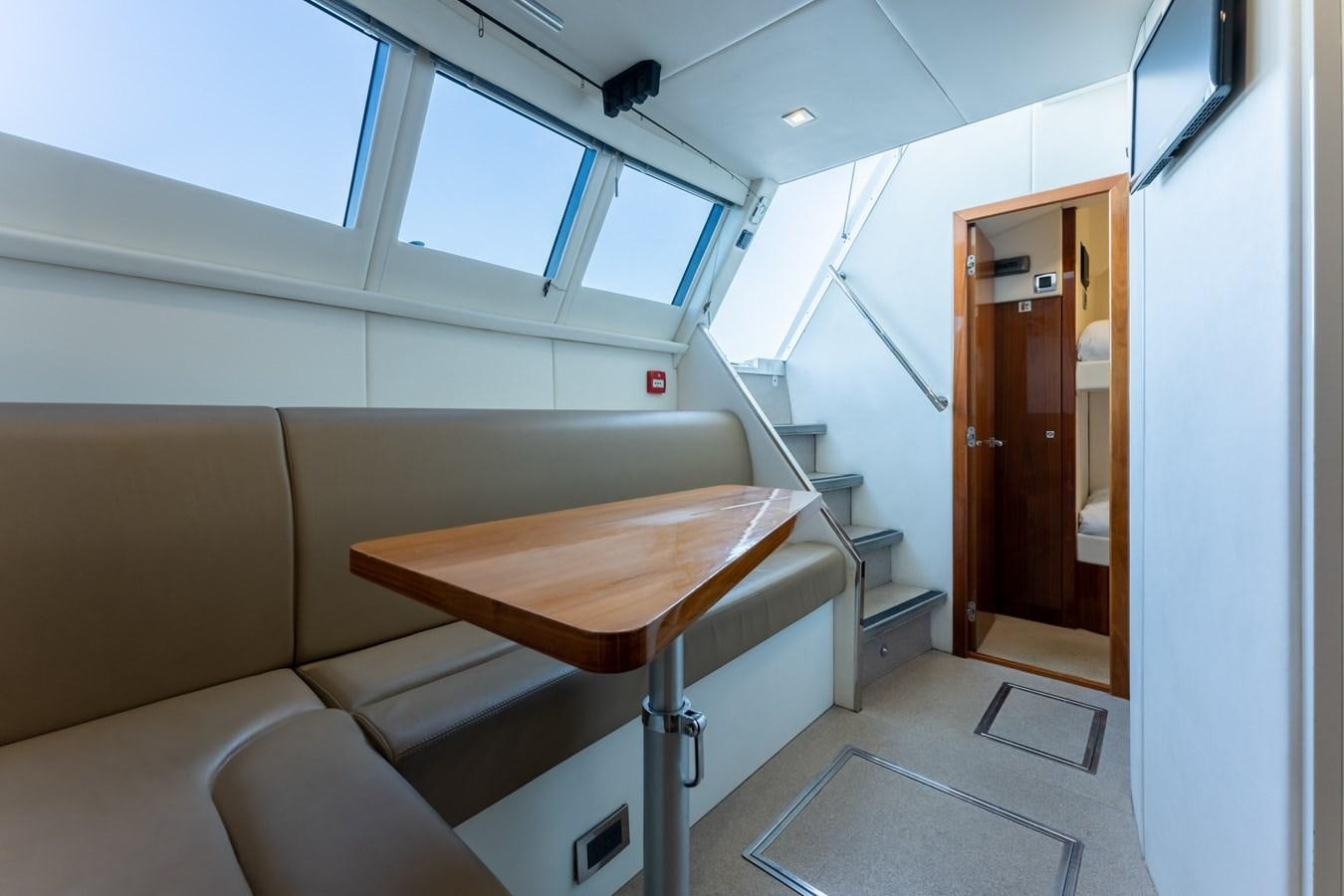 a room with a table and chairs aboard ULTRAVIOLET Yacht for Sale