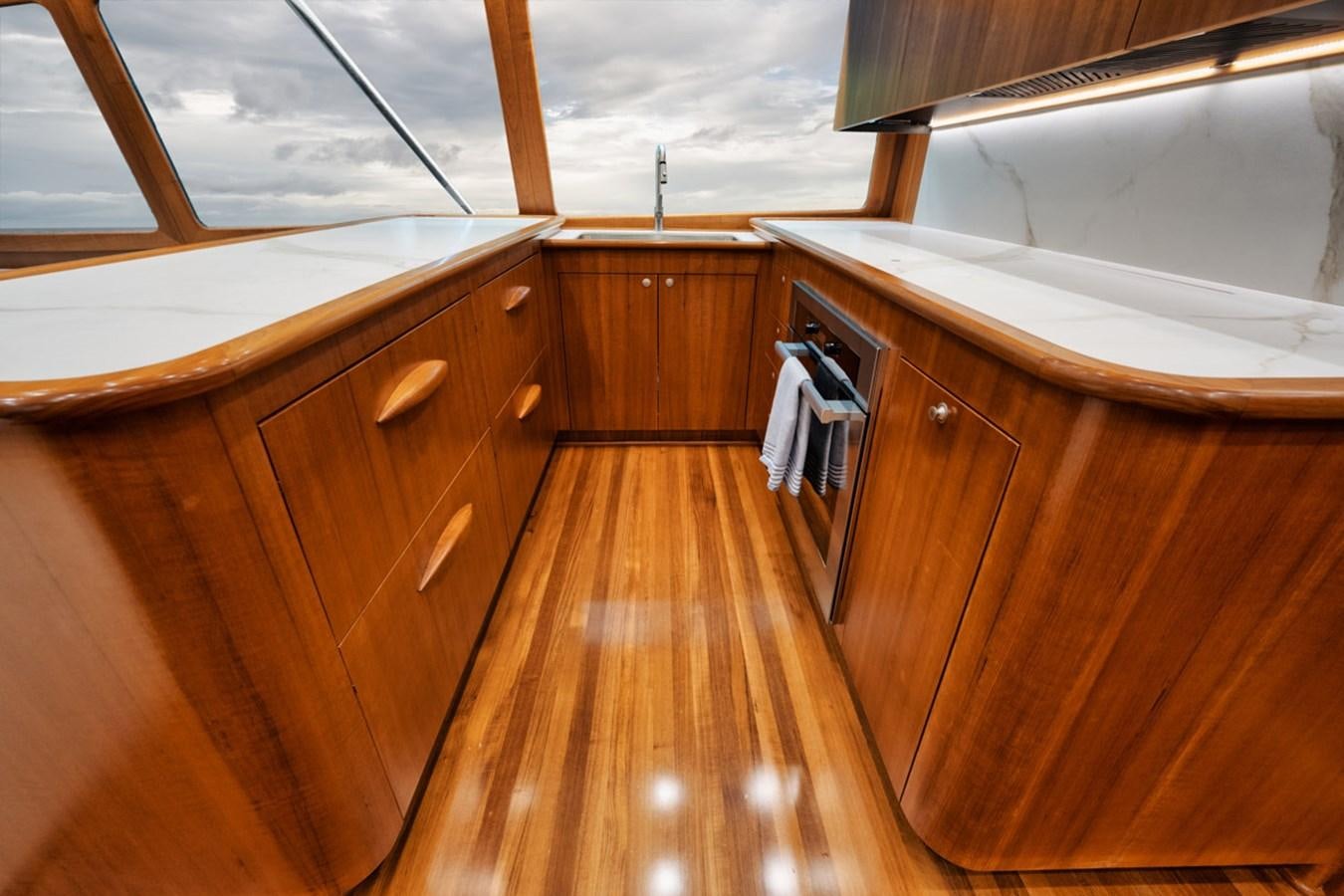 a wooden kitchen with a large window aboard FULL TIME Yacht for Sale