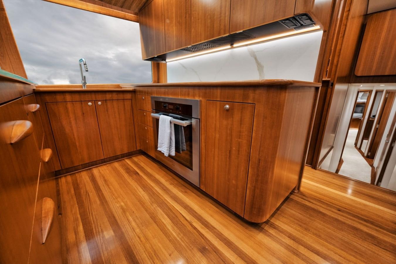 a kitchen with wooden cabinets aboard FULL TIME Yacht for Sale