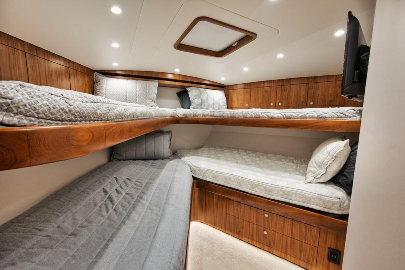 a room with beds and a television aboard FULL TIME Yacht for Sale