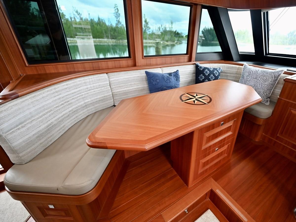 a table with a couch and a window aboard KNOT FLYING Yacht for Sale