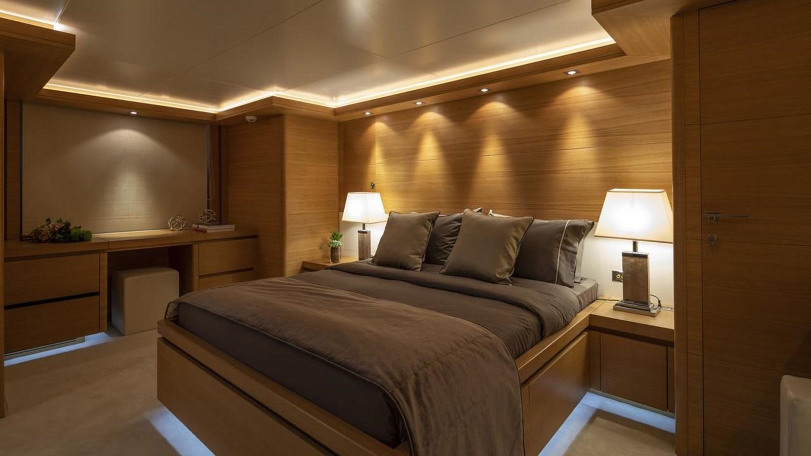 a bedroom with a bed and desk aboard SANSARA Yacht for Sale