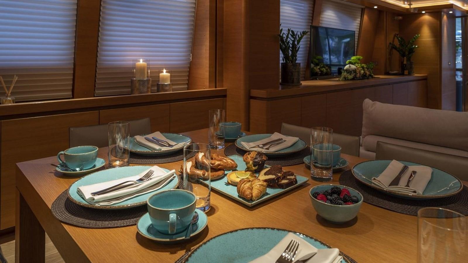a table with plates and glasses on it aboard SANSARA Yacht for Sale