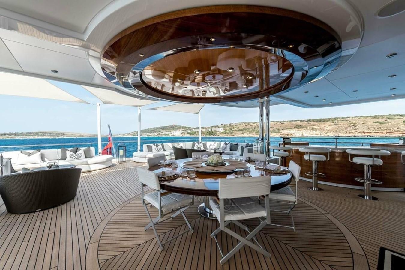 a room with a table chairs and a large round mirror on the ceiling aboard TALISMAN C Yacht for Sale