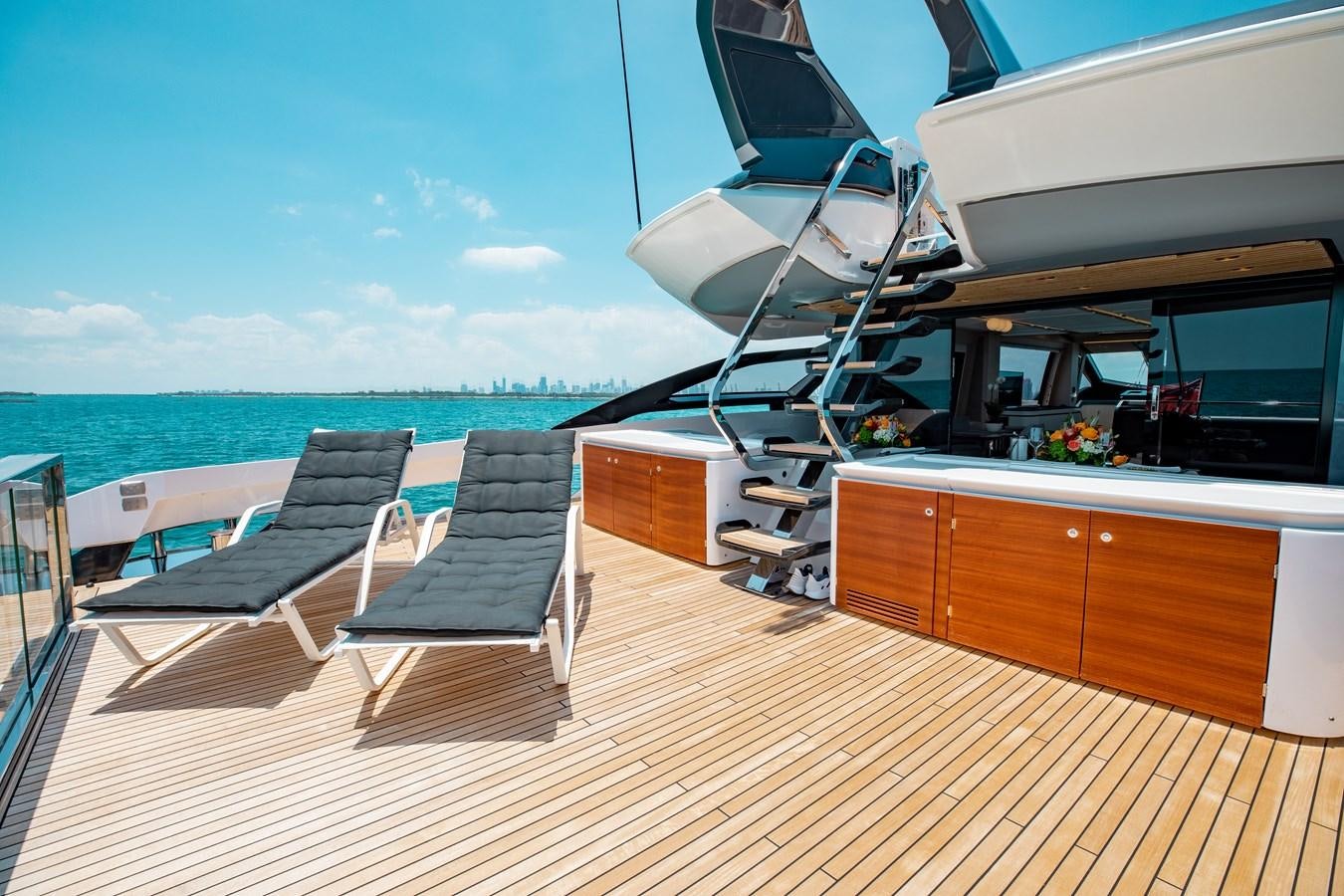 a deck with a chair and a large body of water in the background aboard BASH II Yacht for Sale