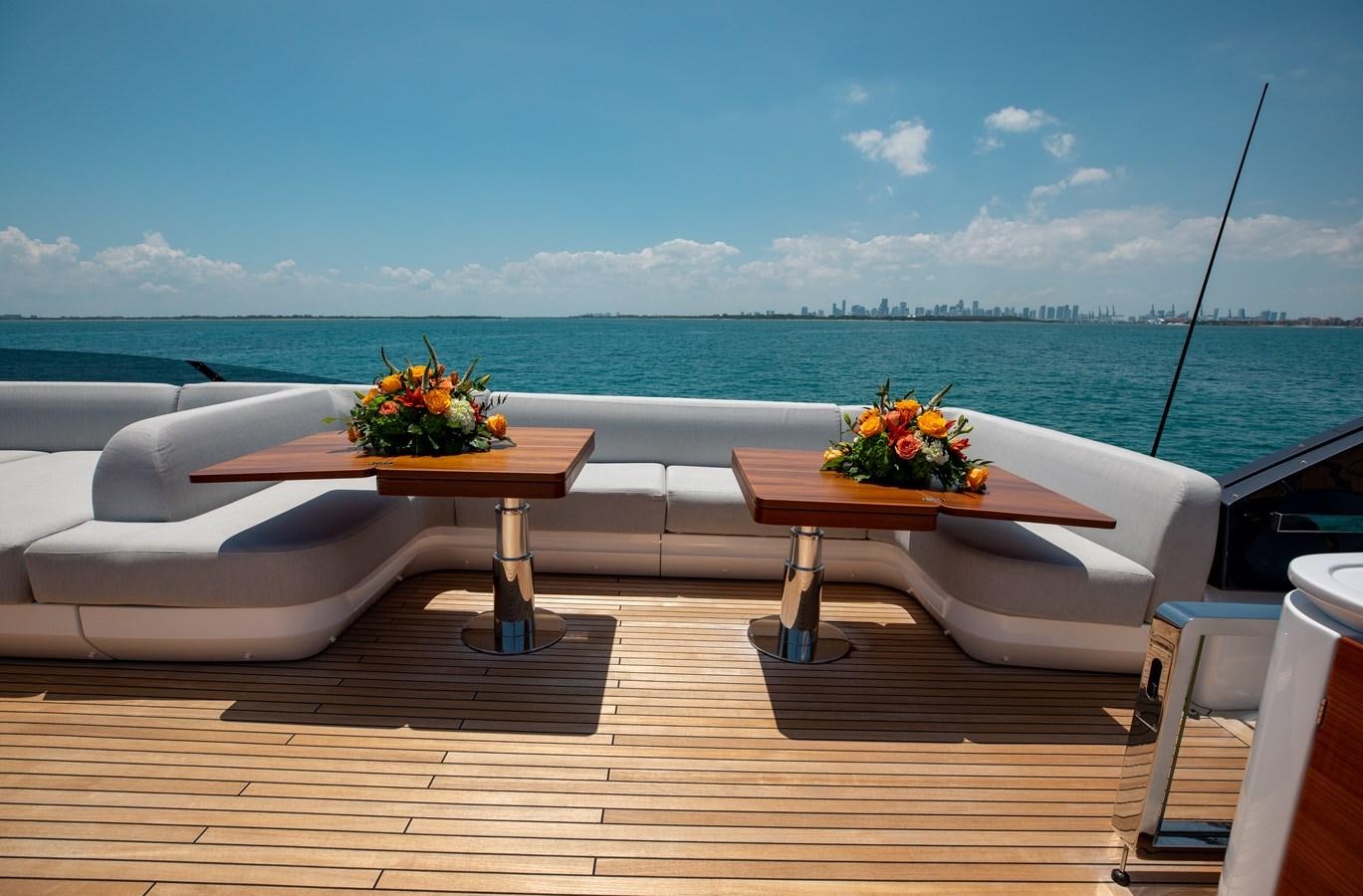 a table and chairs on a deck overlooking a body of water aboard BASH II Yacht for Sale