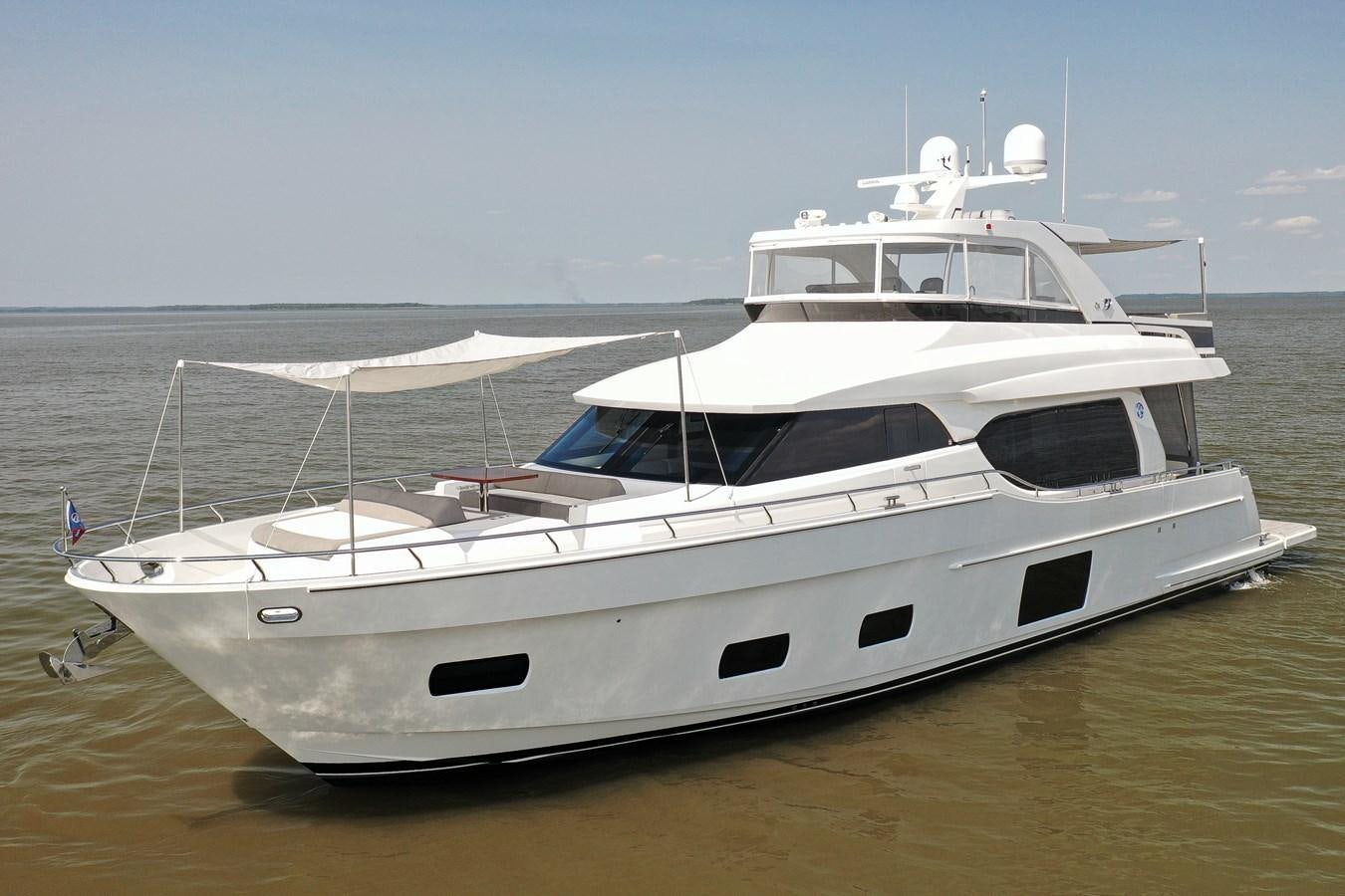 a white yacht on a beach aboard 70E Yacht for Sale