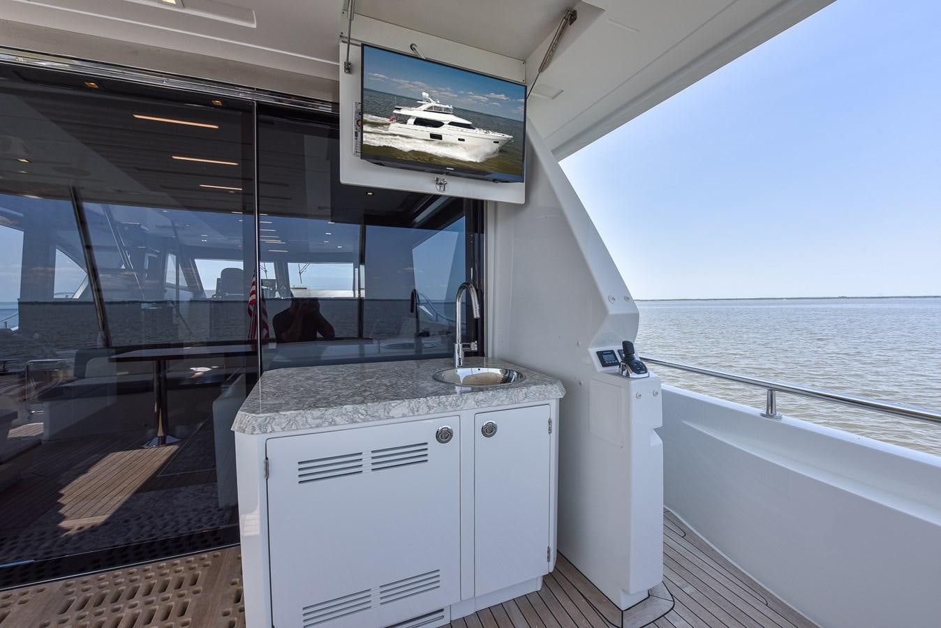 a kitchen with a sink and a television on the wall aboard 70E Yacht for Sale