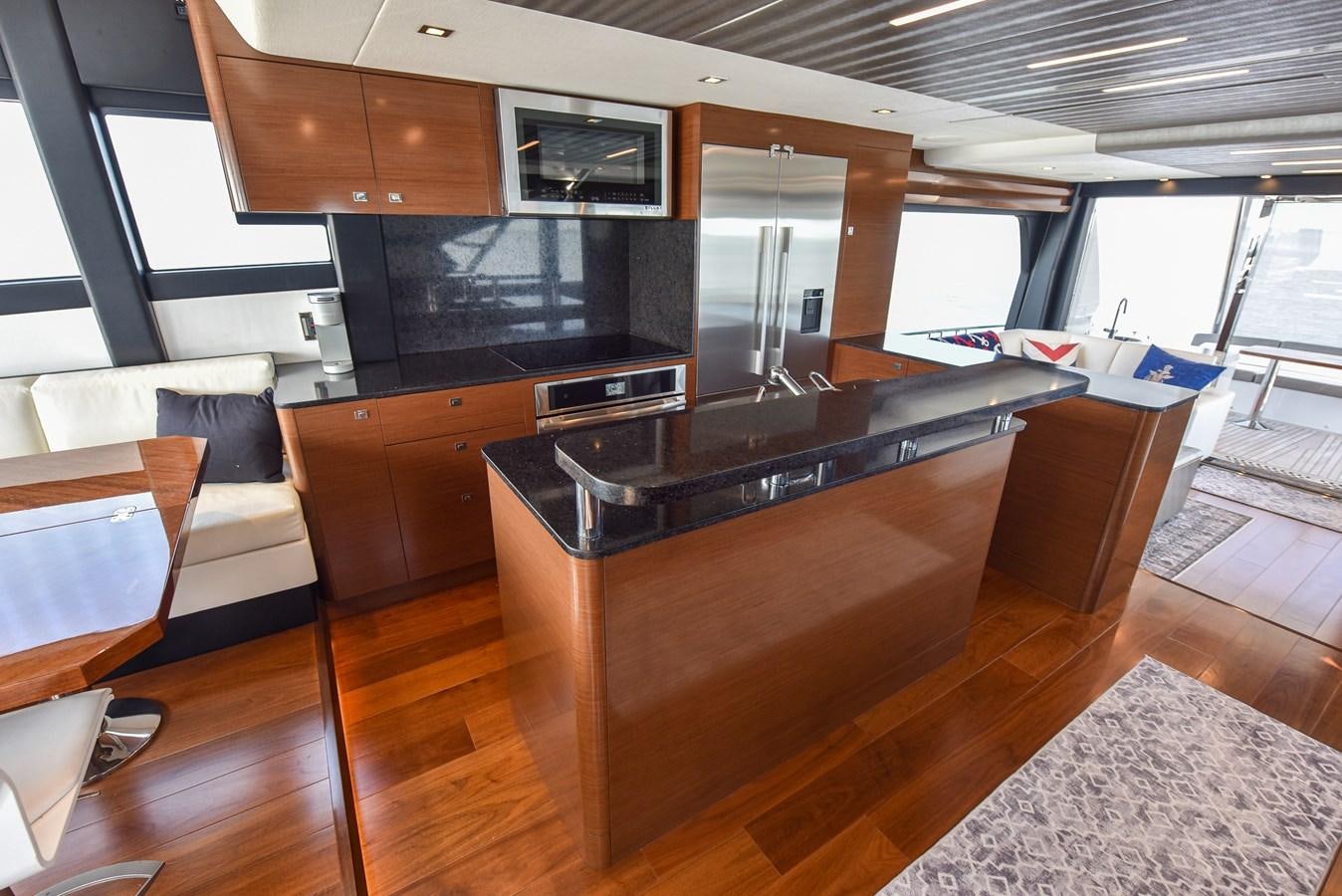 a kitchen with wooden cabinets aboard 70E Yacht for Sale