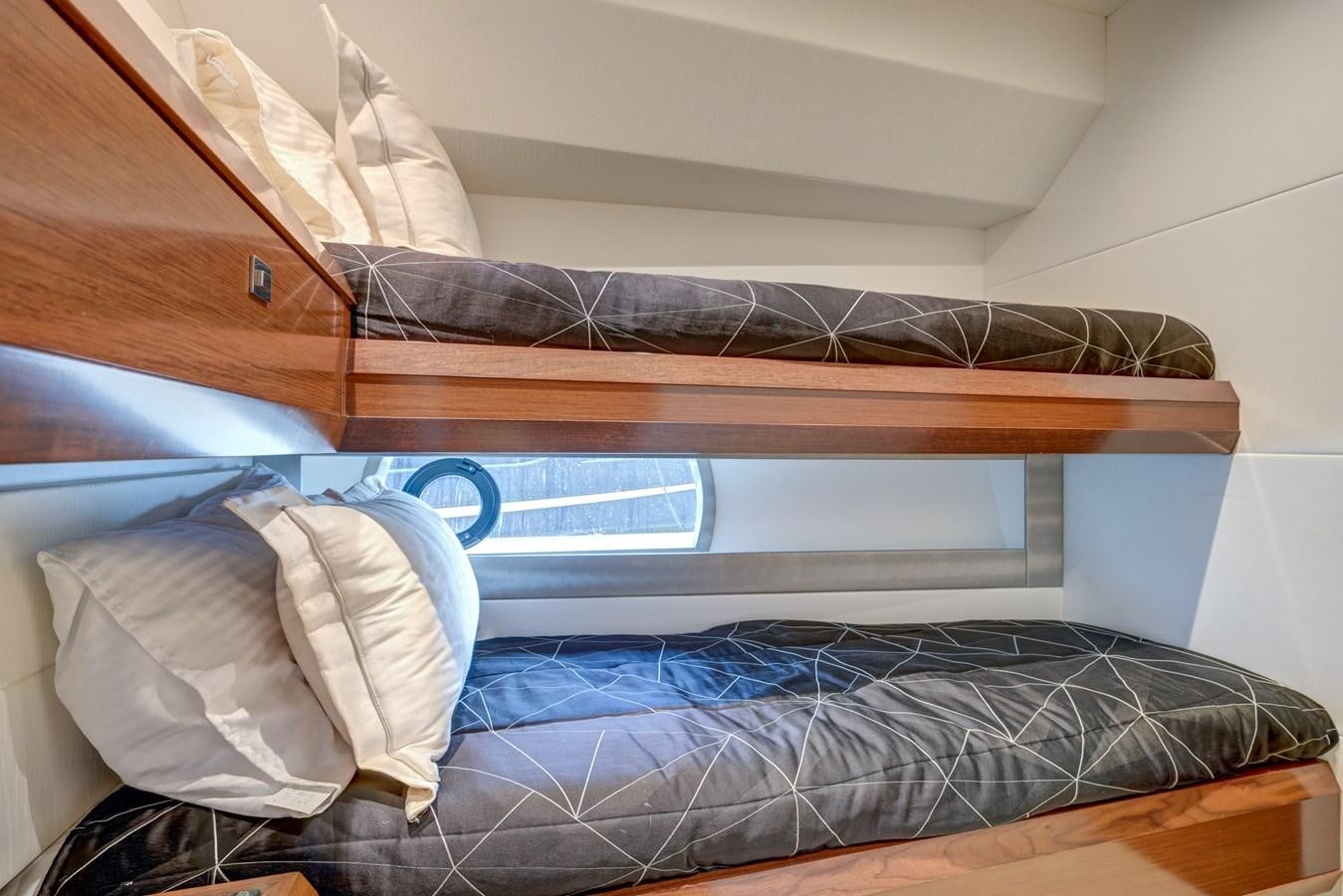a bed with a blue sheet aboard 70E Yacht for Sale