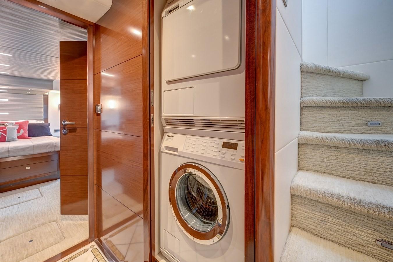 a room with a washing machine and a bed aboard 70E Yacht for Sale
