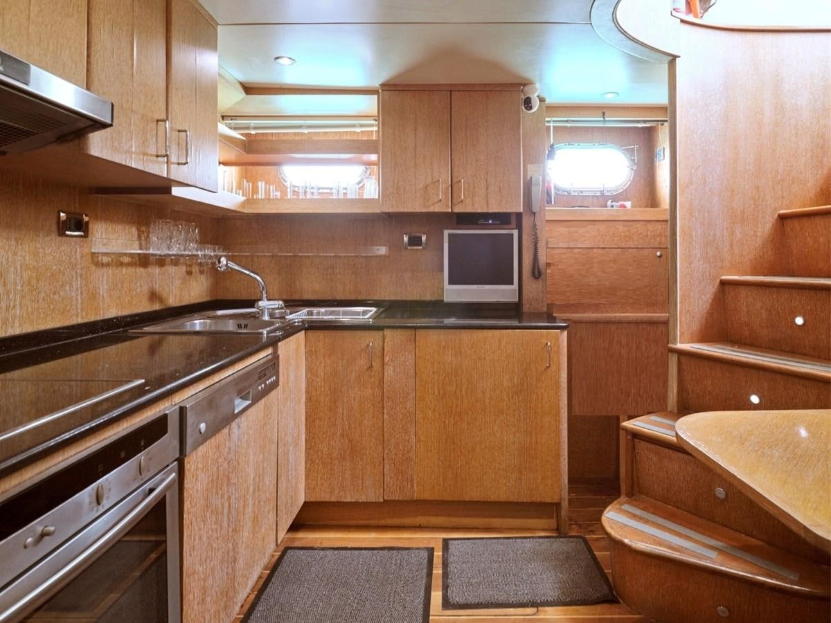 a kitchen with wooden cabinets aboard HUNTING STAR Yacht for Sale
