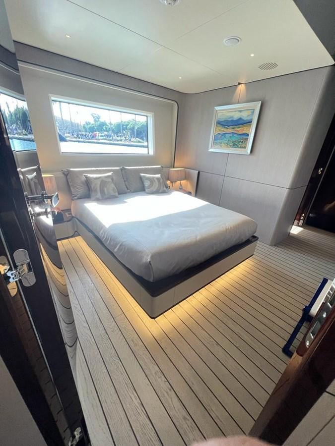 a bedroom with a bed and a window aboard LOVE T Yacht for Sale