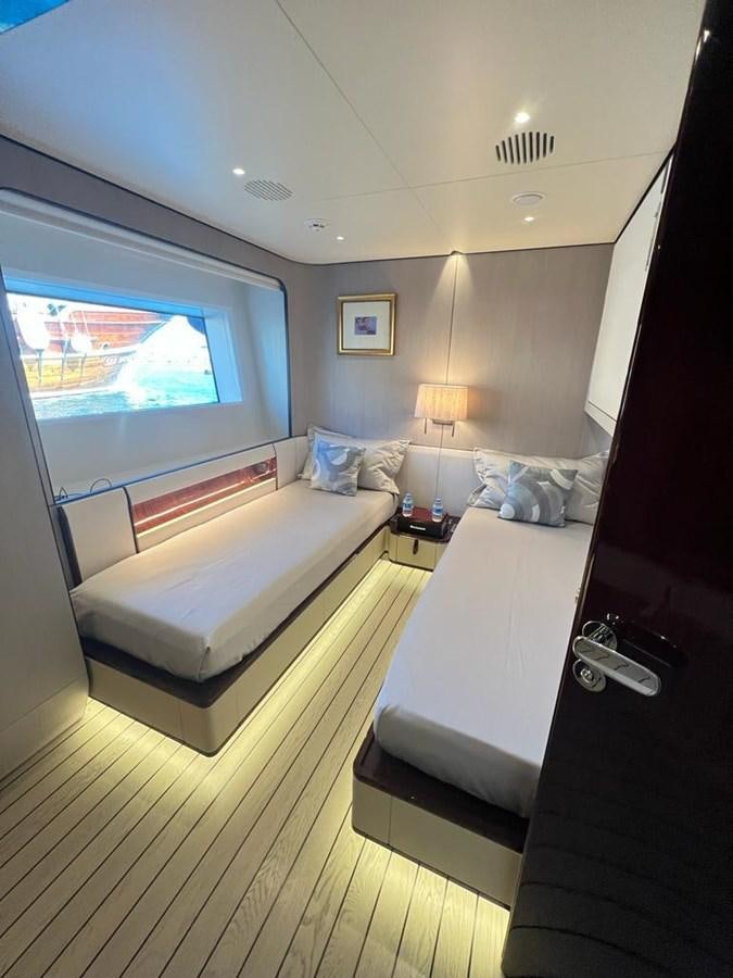 a bedroom with a bed and a window aboard LOVE T Yacht for Sale