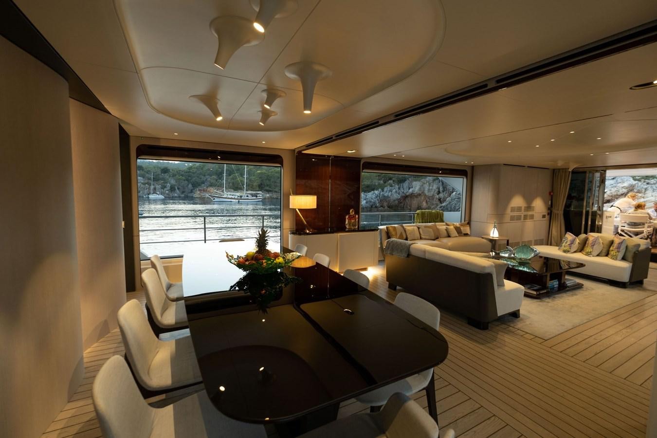 a living room with a table and couches aboard LOVE T Yacht for Sale