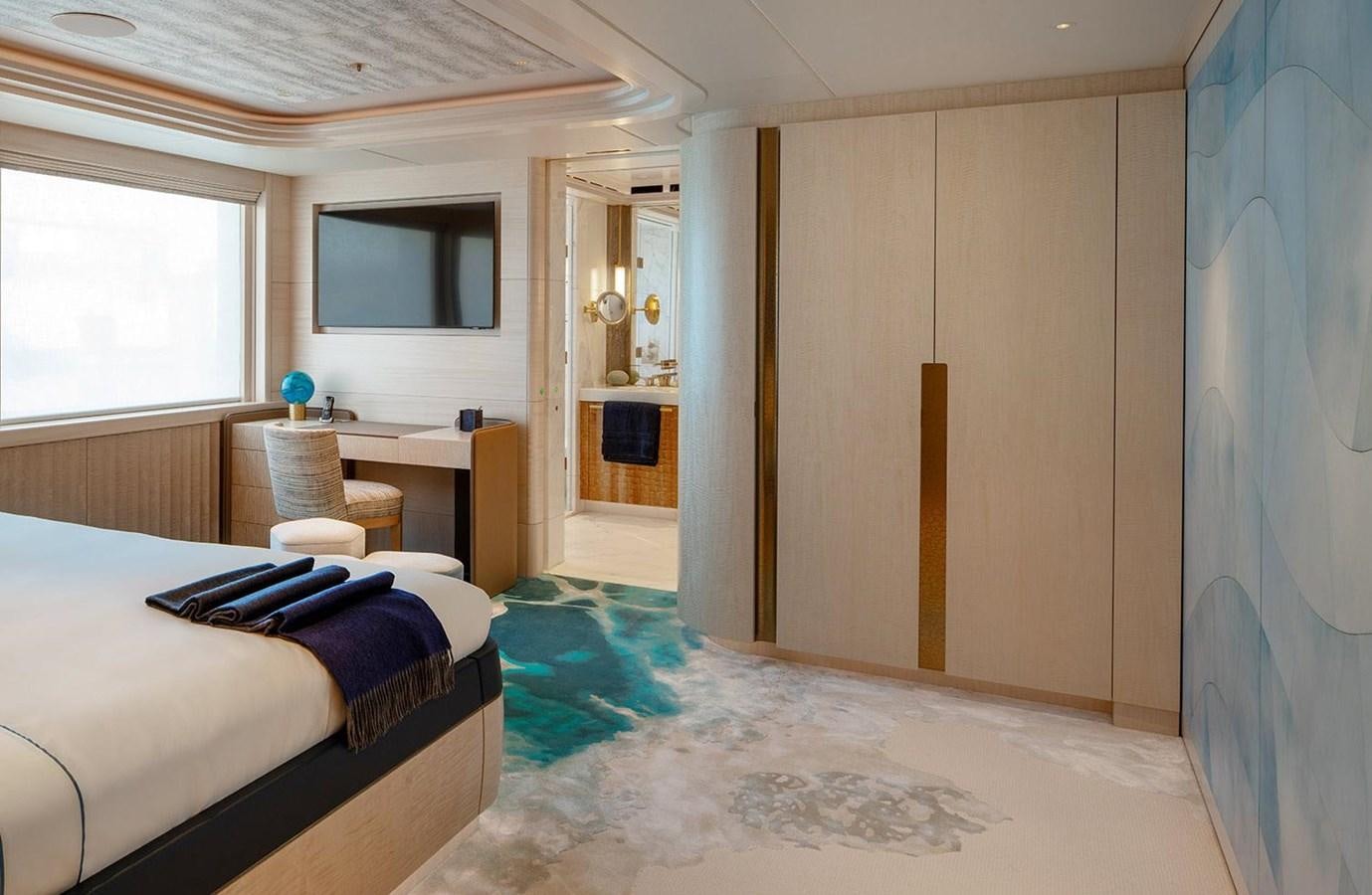 a bedroom with a bed and a desk aboard SPARTA Yacht for Sale
