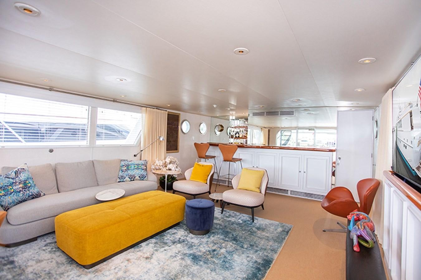 a living room with a yellow couch aboard SOVEREIGN Yacht for Sale