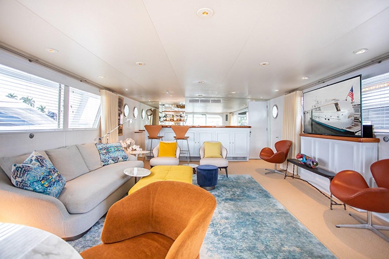 a living room with a large screen aboard SOVEREIGN Yacht for Sale