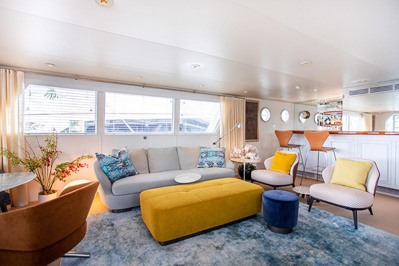 a living room with couches and a table aboard SOVEREIGN Yacht for Sale