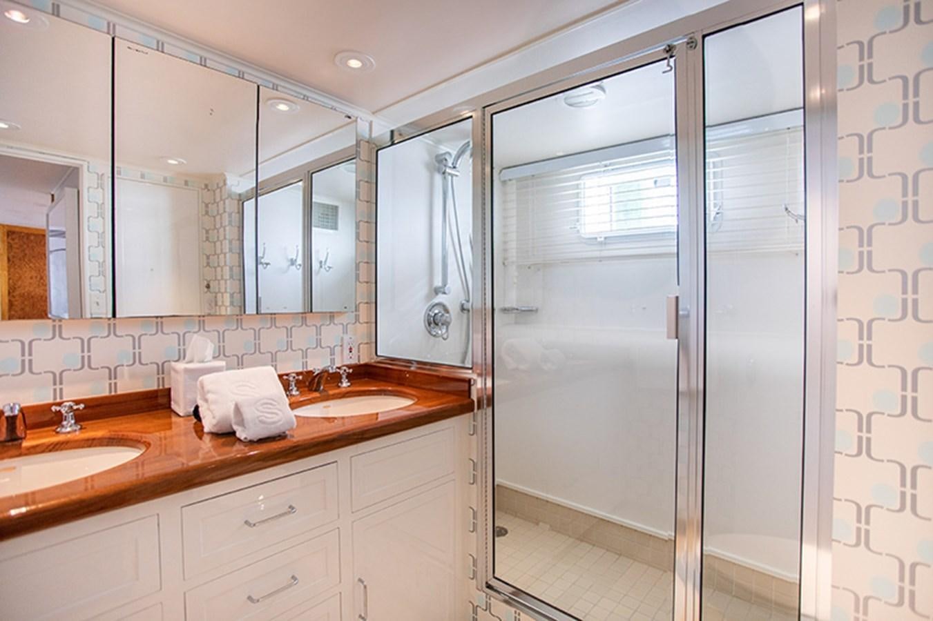 a bathroom with a shower unit and sinks aboard SOVEREIGN Yacht for Sale