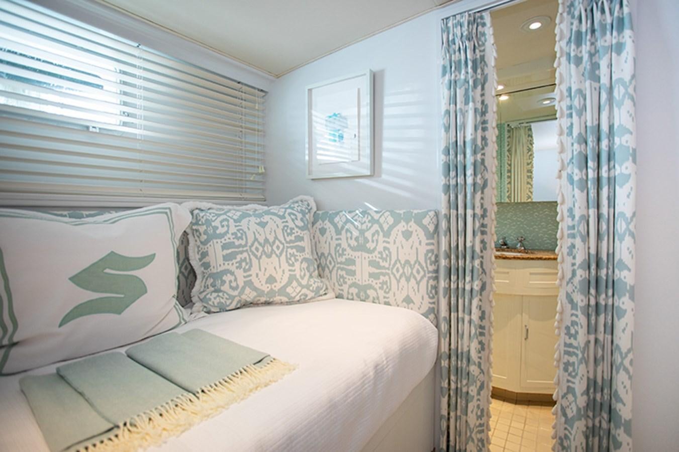 a bed with a book on it aboard SOVEREIGN Yacht for Sale