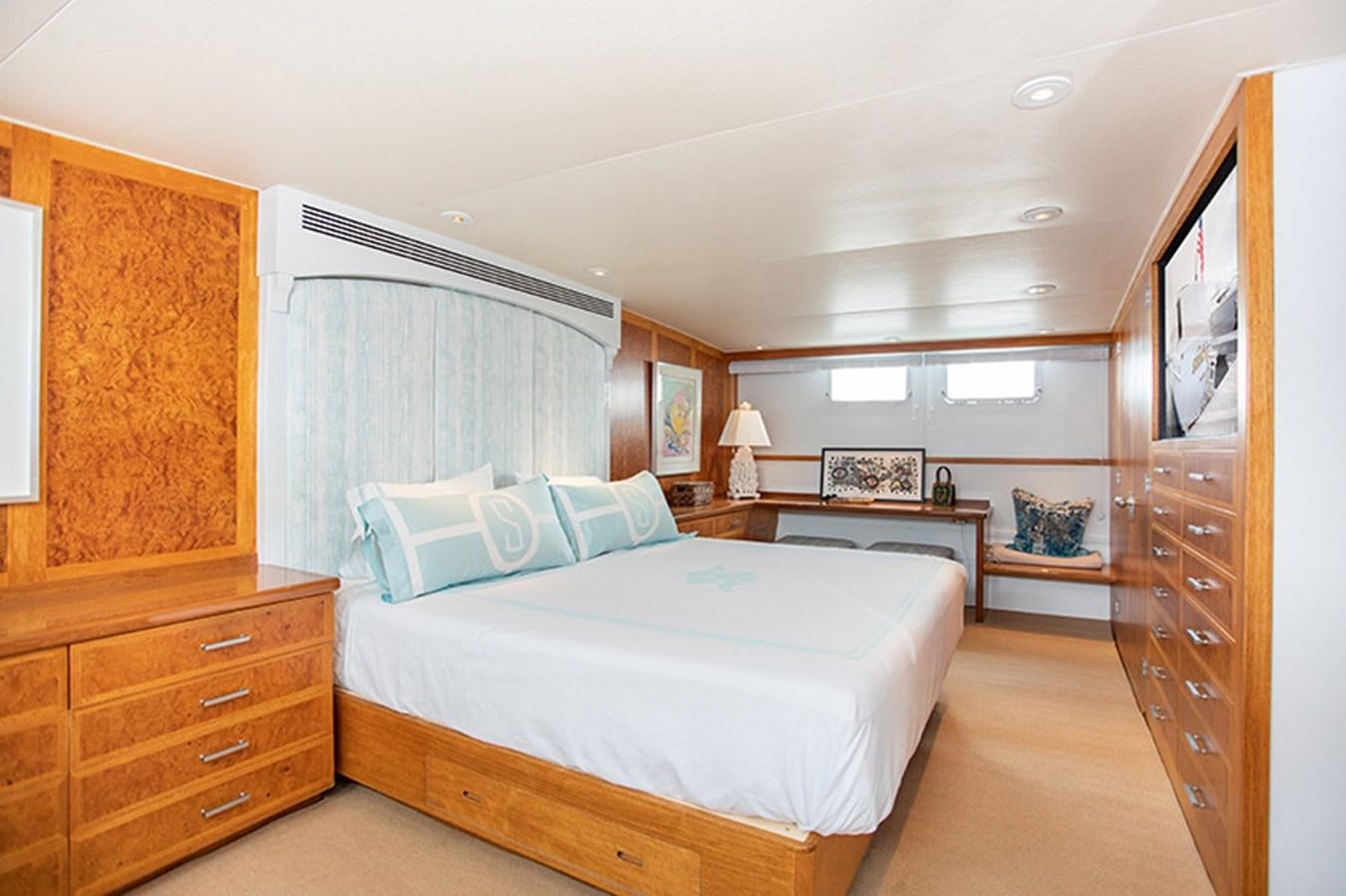 a bedroom with a bed and a desk aboard SOVEREIGN Yacht for Sale