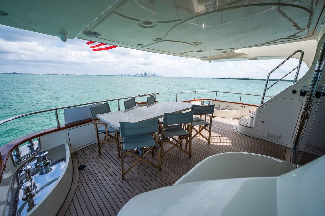 a deck with a table and chairs on it aboard 80 CARAT Yacht for Sale