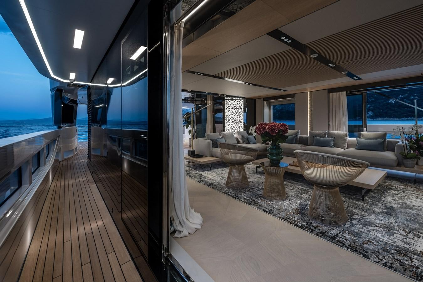 a large living room with a large glass table and a large window aboard UV II Yacht for Sale