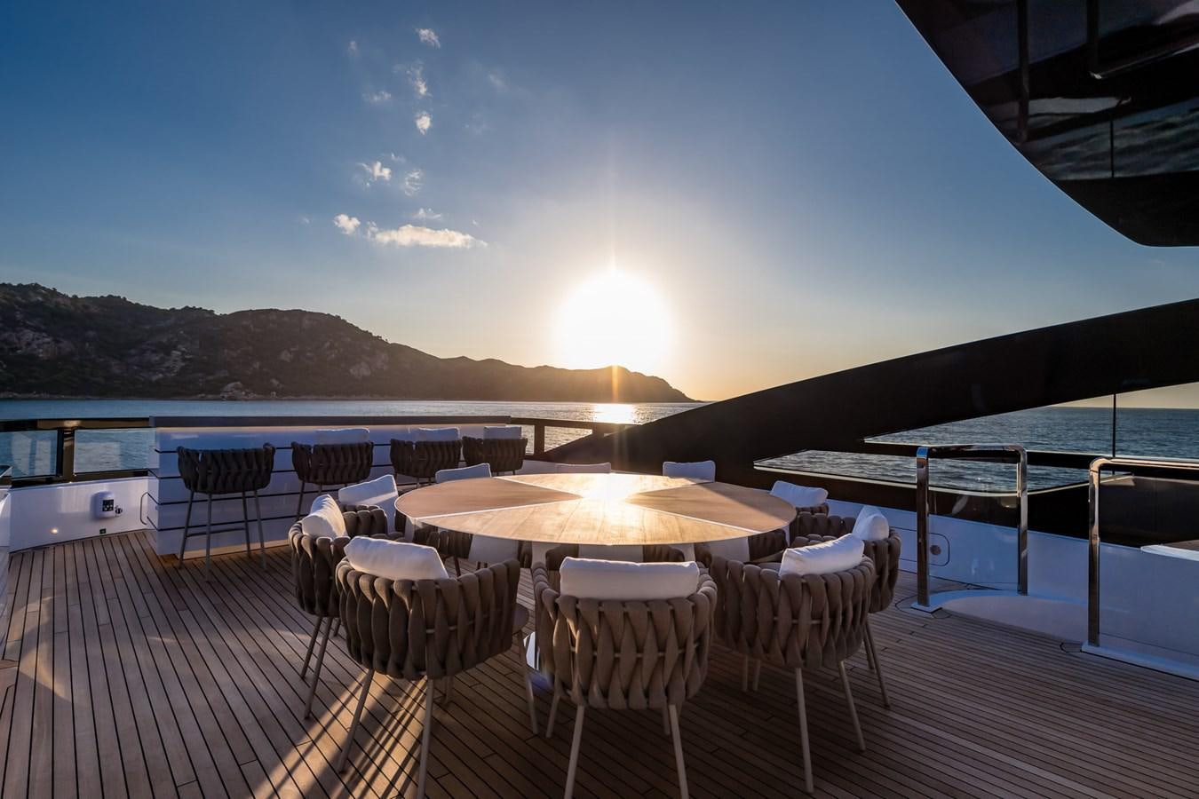 a deck with tables and chairs aboard UV II Yacht for Sale