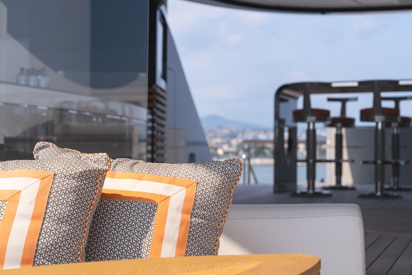 a couch and a table on a patio with a view of a city aboard WHISPER Yacht for Sale