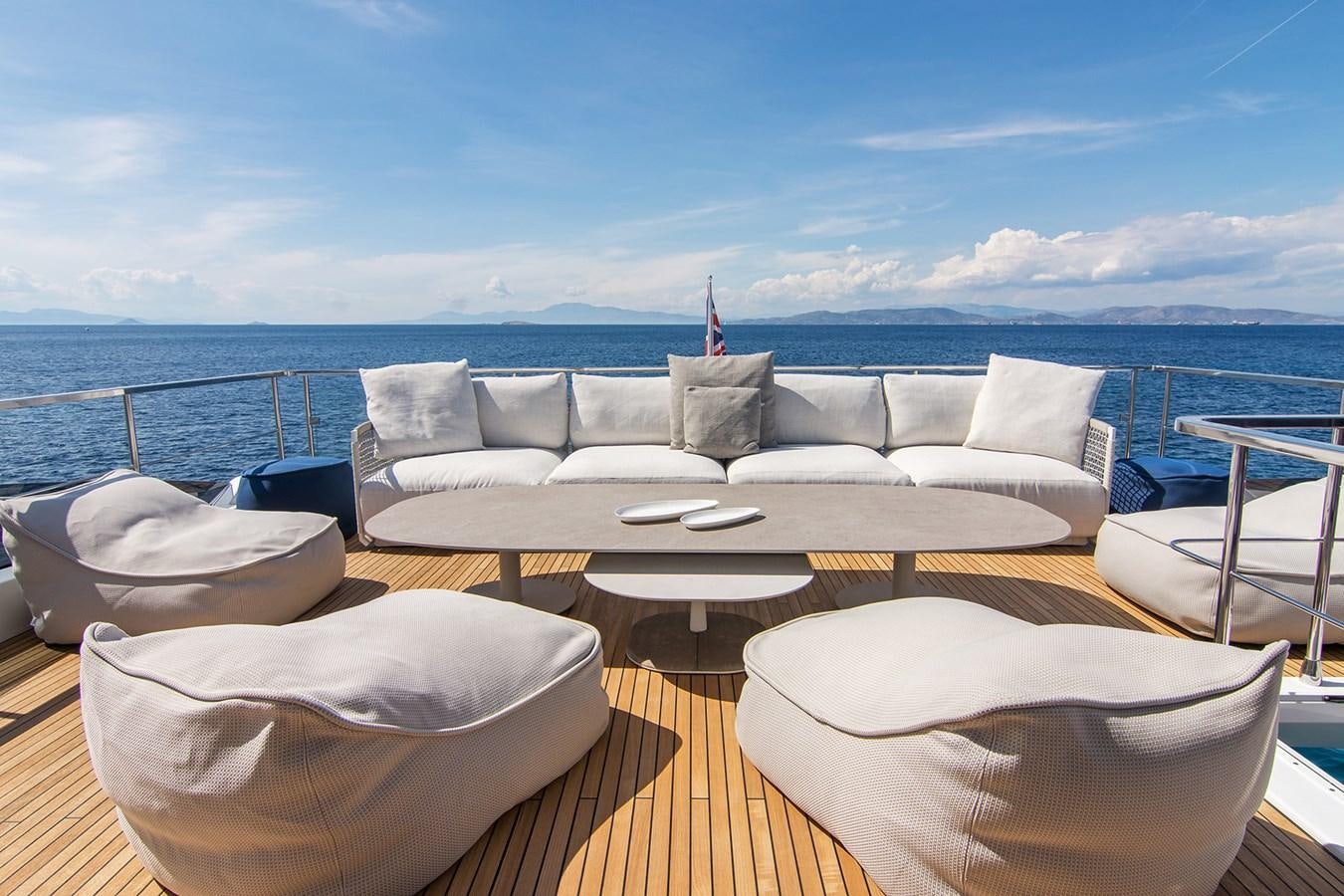 a large white couch on a deck overlooking a large body of water aboard GDL Yacht for Sale