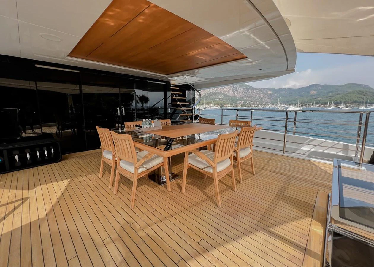 a deck with a table and chairs on it aboard UNASOLA Yacht for Sale