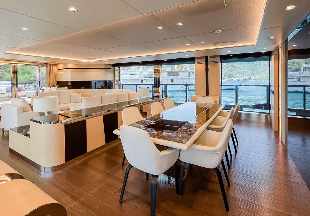 a room with tables and chairs aboard UNASOLA Yacht for Sale