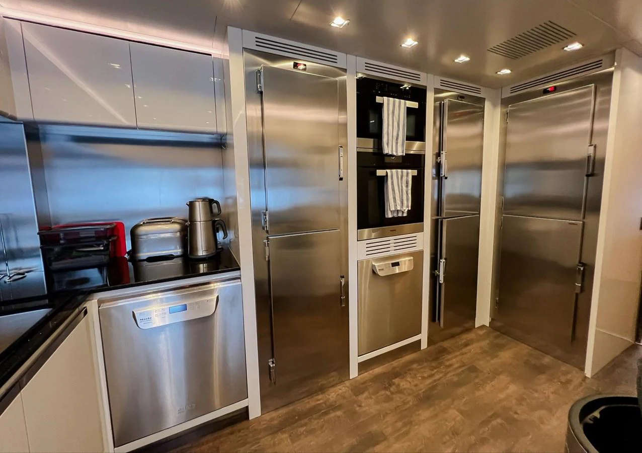 a kitchen with a refrigerator and a microwave aboard UNASOLA Yacht for Sale