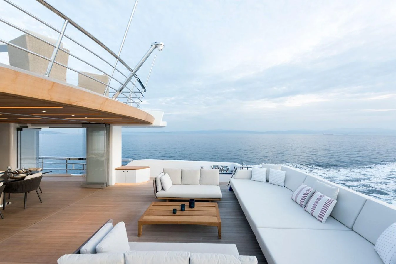 a room with a view of the ocean and a patio with a table and chairs aboard PICCOLO @ FLIBS Yacht for Sale