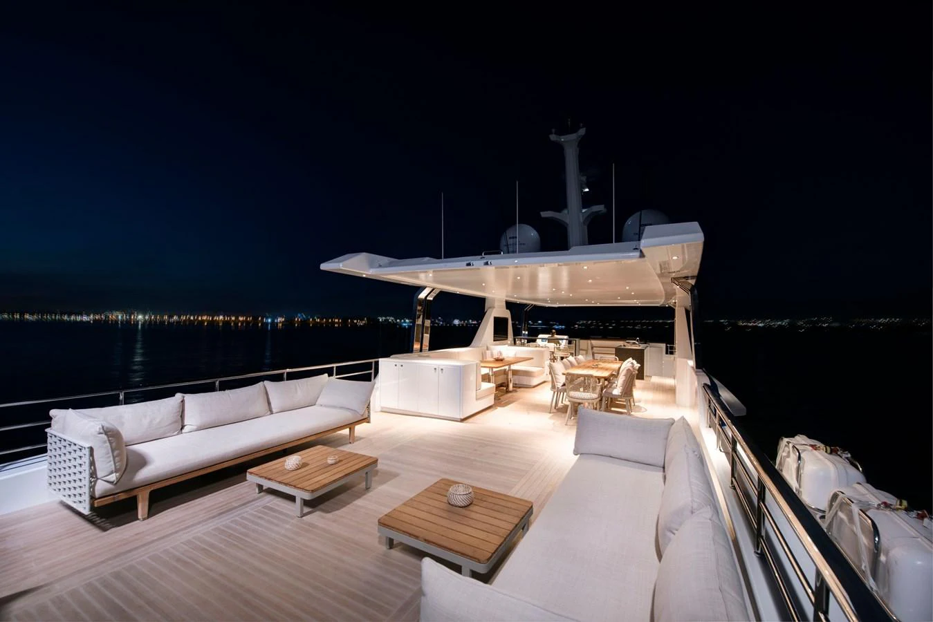 a large white lounge chair on a deck overlooking a large body of water aboard PICCOLO @ FLIBS Yacht for Sale
