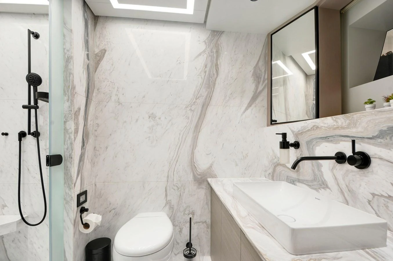 a bathroom with a sink toilet and mirror aboard PICCOLO @ FLIBS Yacht for Sale
